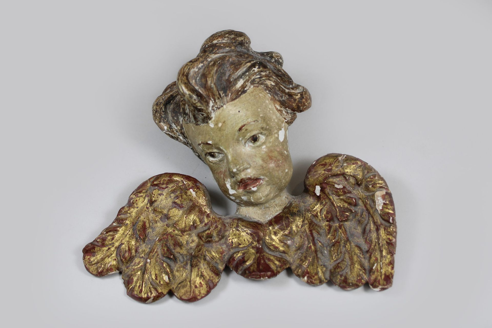 Putto Kopf, Holz, plastisch geschnitzt, polychrom gefasst, Maße: H. 17 cm, B. 20 cm. Altersgemäß