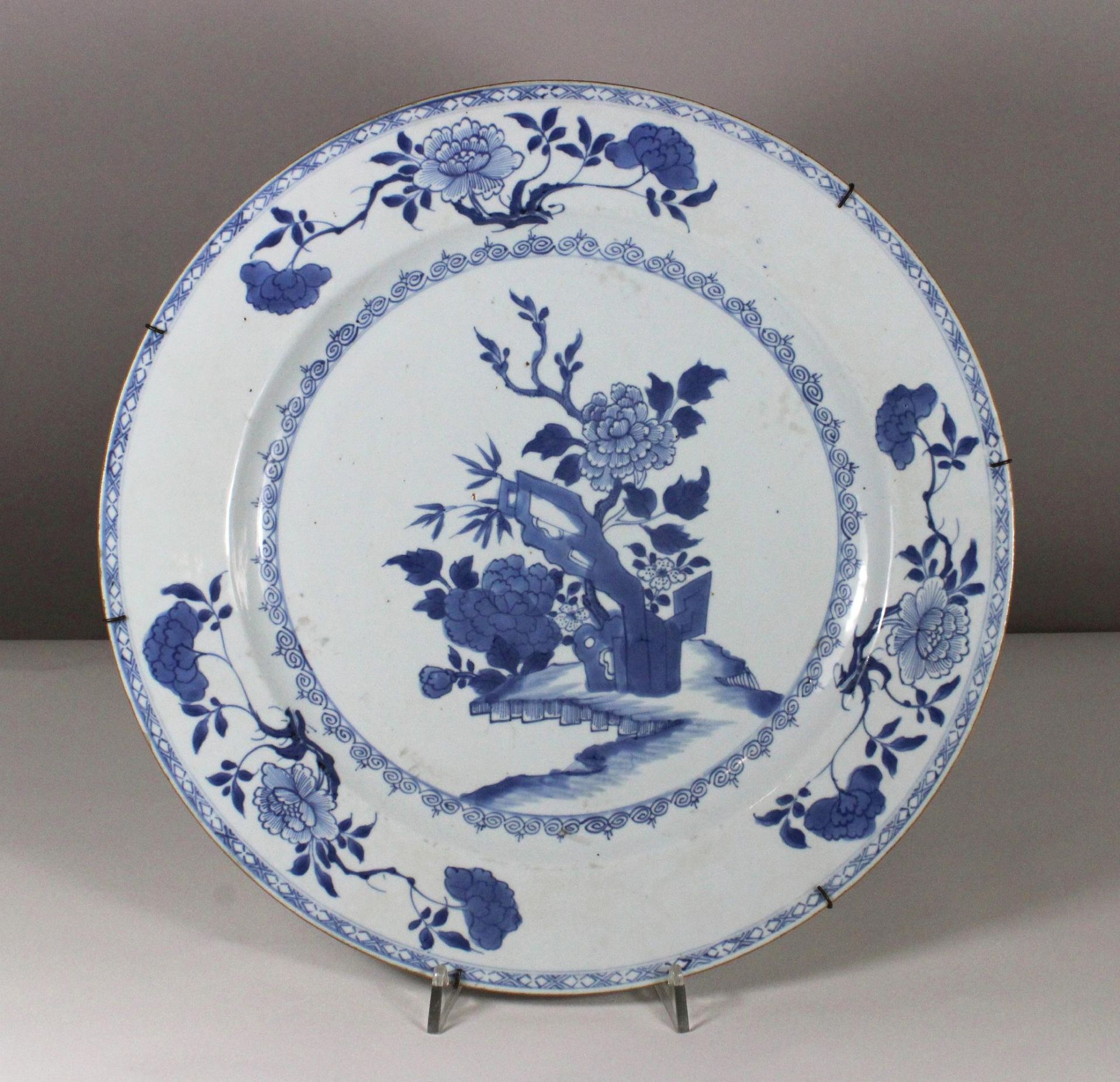 Chinoise Wandteller, Fayence, blau-weiß Unterglasur, Floraldekor, Durchmesser: 38 cm.