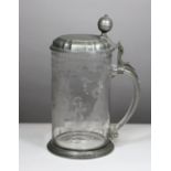 Gravierter Glaskrug mit Zinndeckel, mit Engelmarke, 18. Jh., Maße: H. 26 cm, B. 17 cm. Guter,