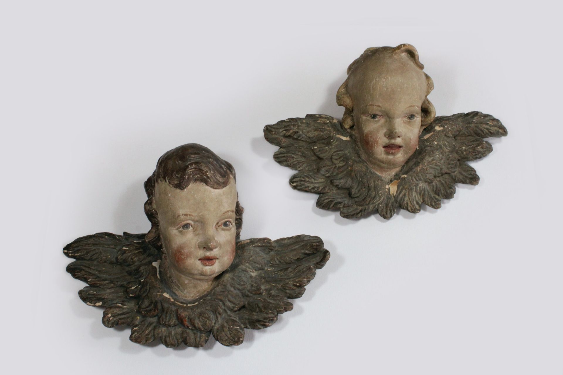 Paar Putti-Köpfe, 18. Jh., Holz, plastisch geschnitzt, polychrom gefasst, Maße: H. ca. 28,5 cm, B.