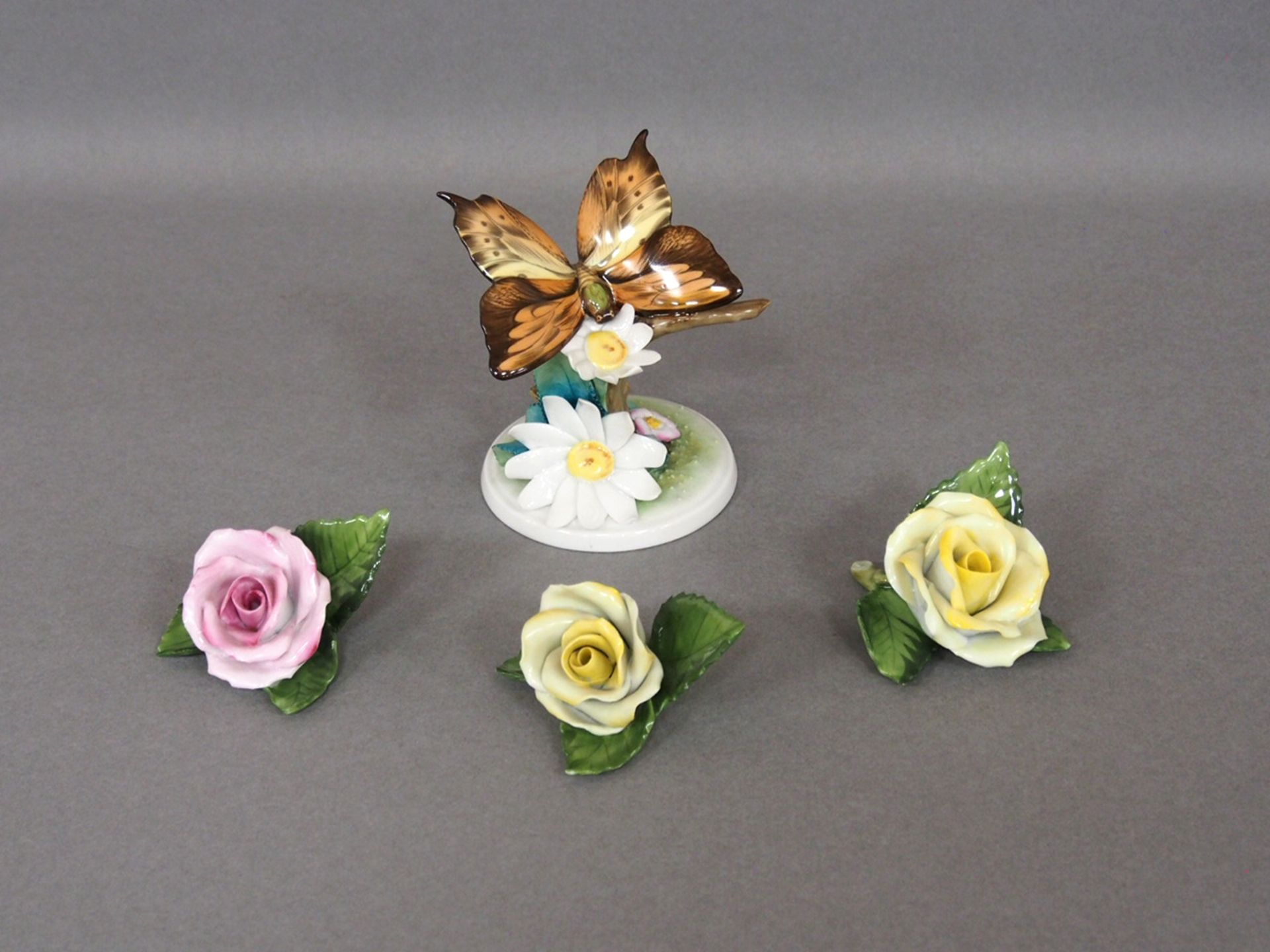 Drei Tischrosen /Schmetterling auf Baumstumpf mit Blumen