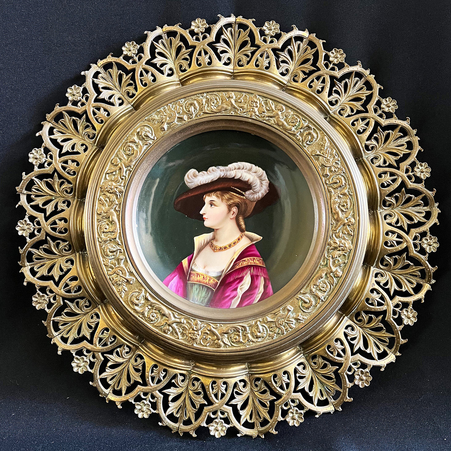 Aufwändiger Messingteller mit Porzellanportrait einer Dame mit großem Federhut. Elaborate round