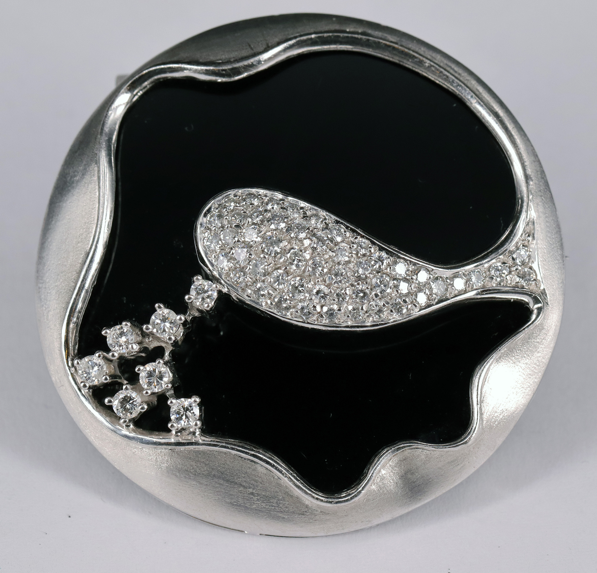 Onyxbrosche / Onyx brooch, 750er WG, kreisrund, mit ca 50 Diamanten besetzt, D. 4,6 cm, 25,48 g