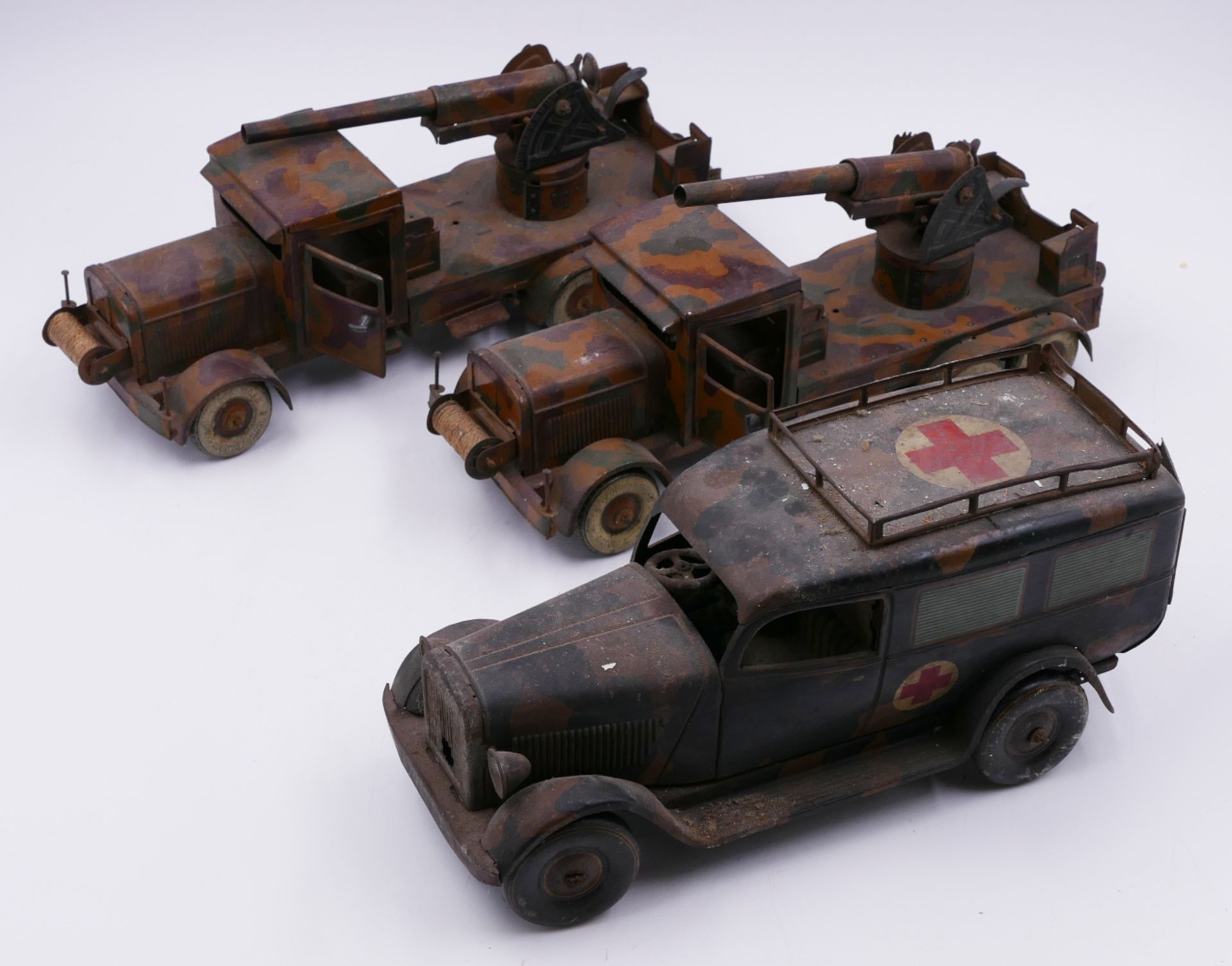 3 Militär-Blechspielzeugautos: 1 Sanitätswagen TIPP&Co. "WH-914" L ca. 23cm mit 1 Figur, 2 LKWs mit 