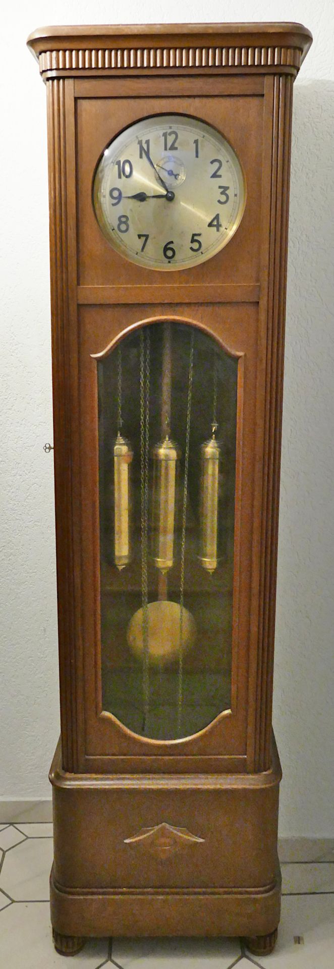 1 Standuhr wohl um 1920 Holzgehäuse, Metallziffernblatt, Pendel, 3 Gewichte, ca. 198x53x30cm, Vierte