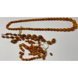 A single strand of butterscotch amber beads, original SBM paper authenticity label; a strand of