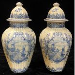 A pair of blue and white Delft baluster vases and covers, each decorated with panels of windmills