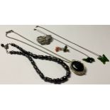 A silver Art Nouveau style necklace, set with a polished black lace agate cabochon, accented with