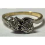 An 18ct gold and platinum two stone diamond crossover ring