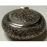 An Anglo-Indian silver coloured metal circular pot and cover, hinged cover, chased and engraved with