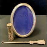 A Siam silver needle case, embossed with Buddhist motifs; oval easel picture frame; etc (3)