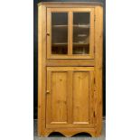 A Victorian pine floor-standing corner cupboard, glazed door to top, and two-panel pine door to