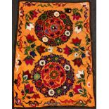 An Uzbeck Suzanie wall hanging / throw, woven in bright shades of purple, magenta, red, green, and