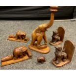 A carved Burmese teak table lamp as a elephant trunk erect, 44cm high; pair of similar book ends;