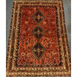 A South-west Persian Shiraz carpet, hand-knotted in earthy shades of red, brown, cream, and deep