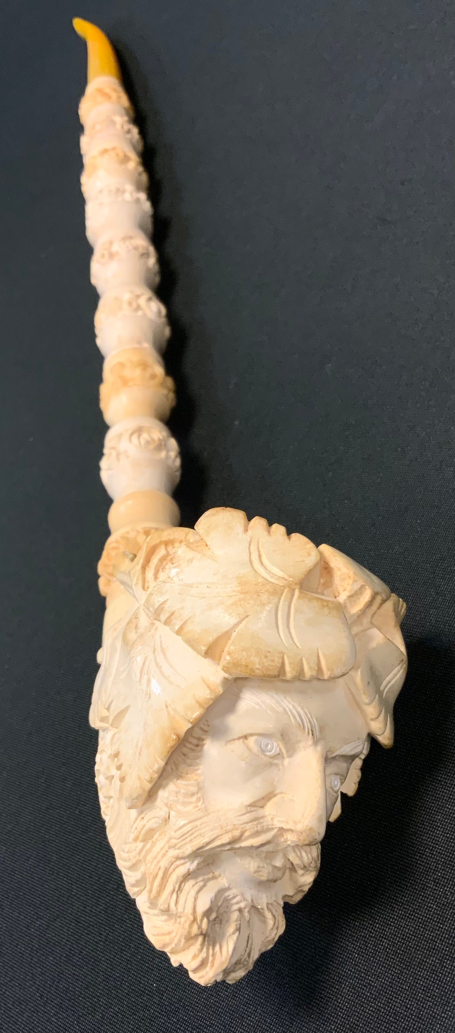 A large meerschaum pipe, carved with the Green Man, leaves and grapes, amber mouth piece, 44cm long,