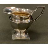 A George V silver cream jug, octagonal tapering body, S W Smith & Co, Birmingham 1921, 7.4cm high,