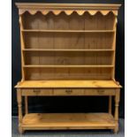 A pine Welsh Dresser, three tier plate rack back, above base with three short drawers, brass swan-