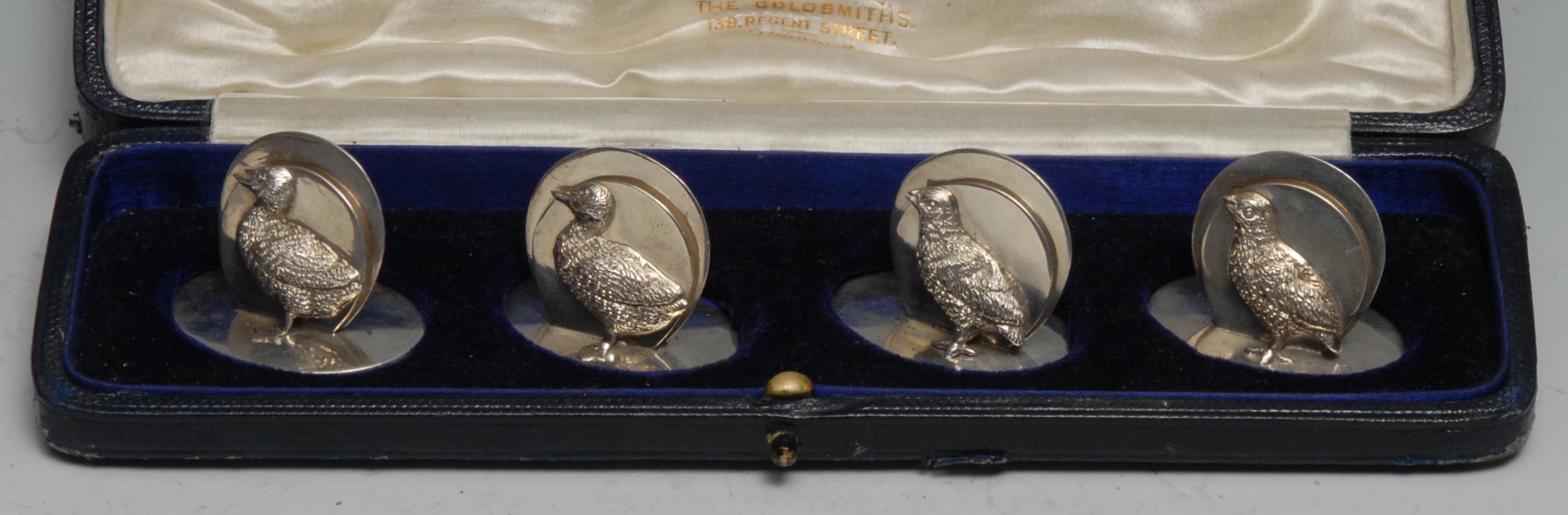 A set of four George V silver novelty menu holders, as ducks, oval bases, 4cm wide, retailed by