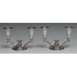 A pair of Modernist silver two-branch table candelabra, domed circular bases, 17cm wide, Henry