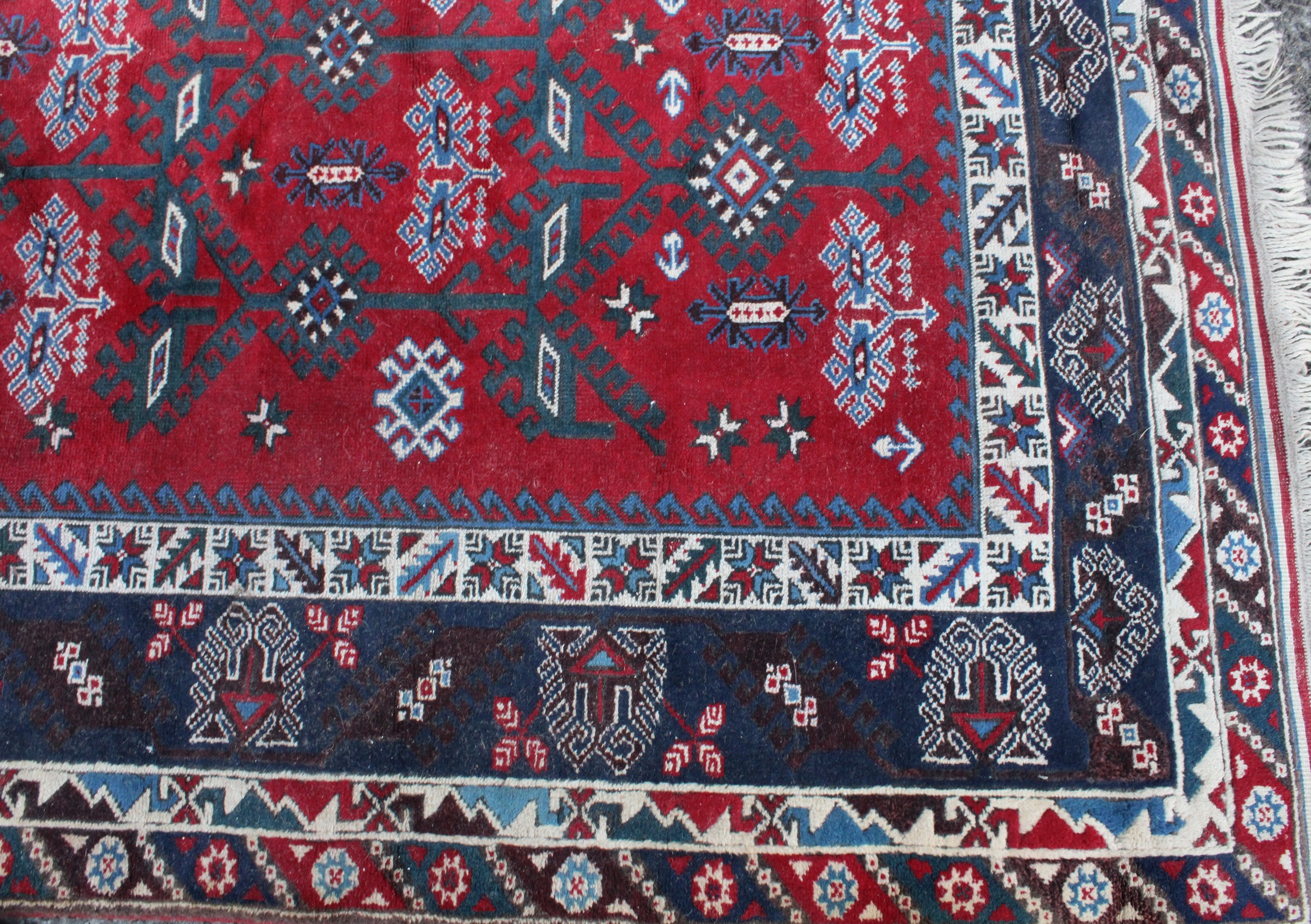 A Middle Eastern rectangular wool rug or carpet, the field worked with hooked medallions and - Image 2 of 5