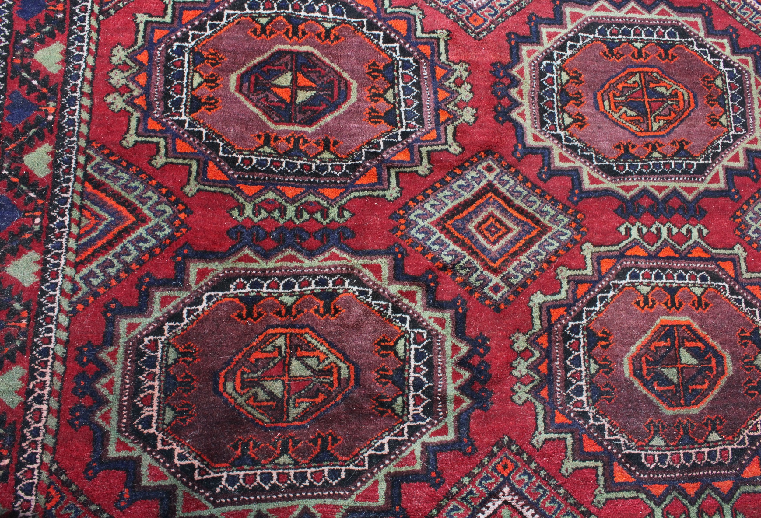 A Middle Eastern rectangular wool rug or carpet, the field worked with hooked medallions and - Image 3 of 5