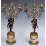 A pair of 19th century gilt and dark patinated bronze figural three-light candelabra, each cast as a