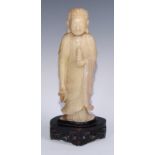 A Chinese soapstone figure, carved as Buddha holding a pagoda, carved hardwood stand, 41cm high,