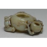 A Chinese celadon jade brush washer, carved with a figure and blossom alongside a peach, 11cm wide
