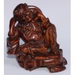 A Chinese hardwood carving, of a monk, reclining, wearing a string of prayer beads, 16.5cm high,