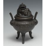 A Chinese bronze tripod censer and cover, surmounted by a temple lion, lappet border, loop handles