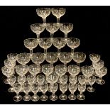 A set of Edwardian star cut glass champagne slippers and port glasses (approximately 40)