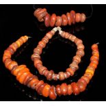 A string of amber beads of flattened graduating asymmetrical form (possibly ancient Egyptian),
