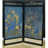 An Aesthetic period ebonised two-fold screen, set with Chinese textile panels on a blue painted