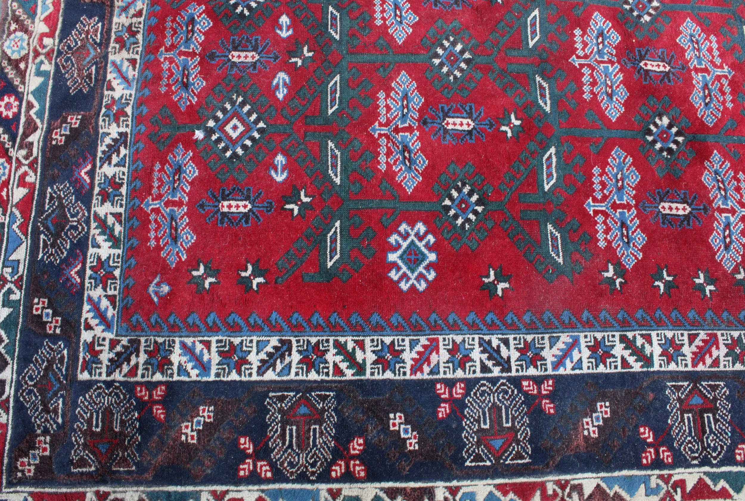 A Middle Eastern rectangular wool rug or carpet, the field worked with hooked medallions and - Image 3 of 5