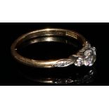 An 18ct gold and platinum three stone diamond ring, diamond chips to navette shaped shoulders,