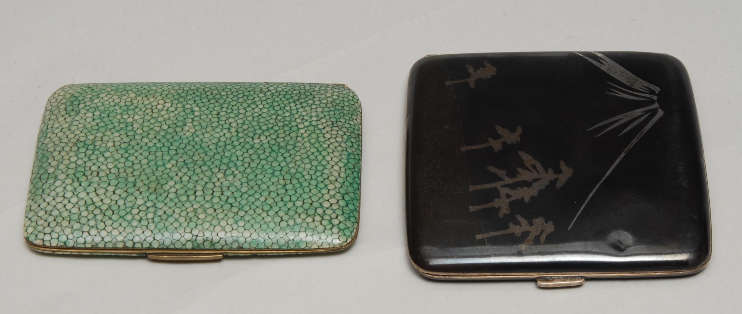 A Japanese silver coloured metal curved rounded rectangular cigarette case, decorated with Mount