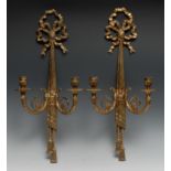 A gilt metal two-light wall lights, ribboned tied, cast with drapes, 60cm high