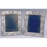 A pair of large Art Nouveau silver rounded rectangular photograph frames, embossed with flowers,