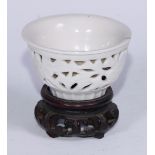 A Chinese blanc de chine reticulated wine cup, 7.5cm diam, hardwood stand
