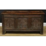 An 18th century oak blanket chest, hinged top enclosing a till above a three panel front carved with