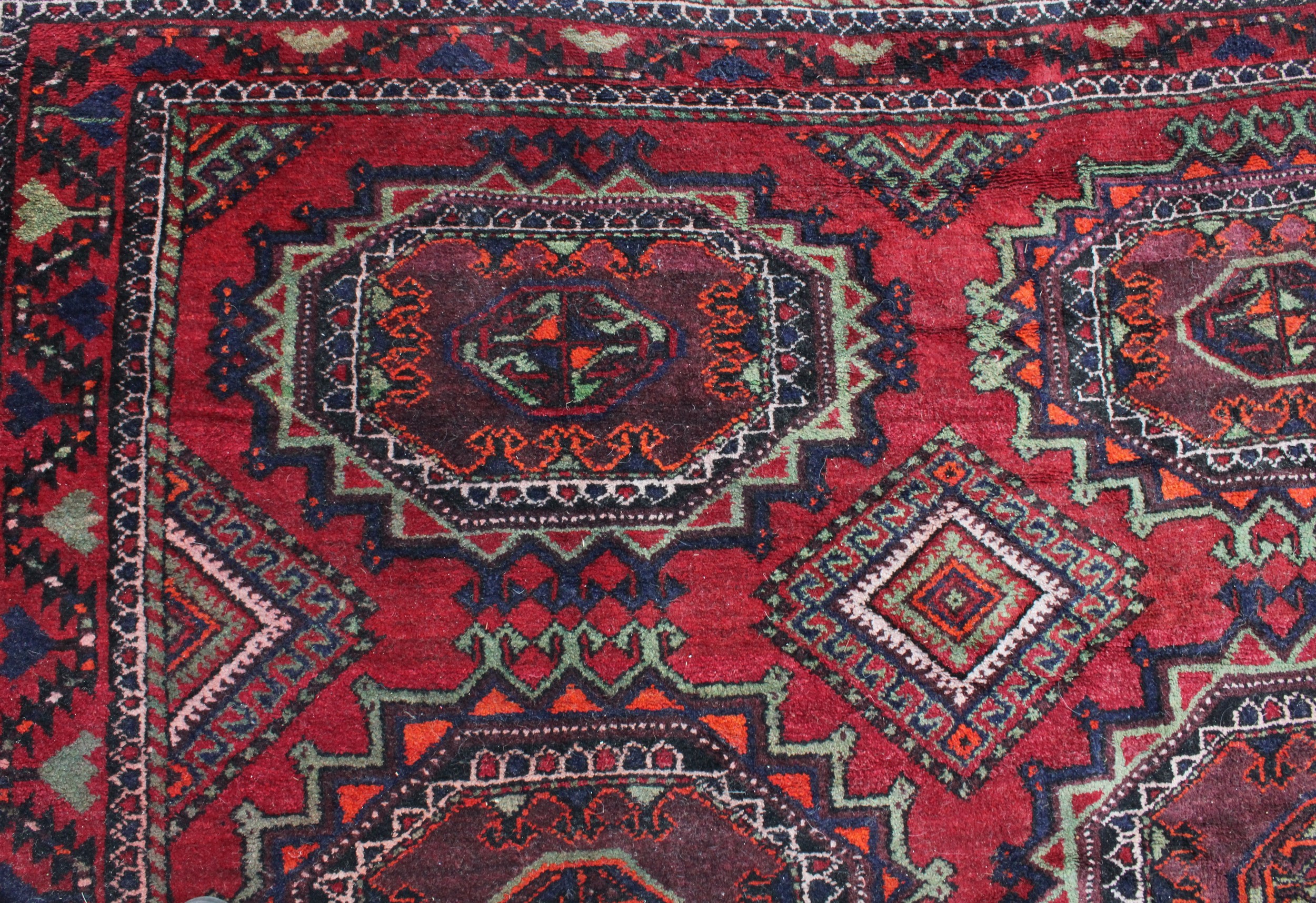 A Middle Eastern rectangular wool rug or carpet, the field worked with hooked medallions and - Image 5 of 5