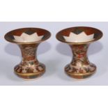 A pair of Japanese satsuma waisted ovoid vases, finely painted with figures in a pagoda landscape,