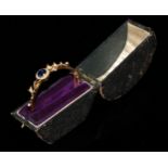 A late 19th/early 20th century 15ct gold hinged bangle bracelet, set with a central sapphire