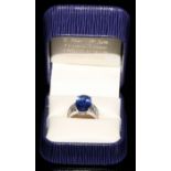 An 18ct white gold diamond and tanzanite ring, 5.83ct central oval tanzanite, flanked by ten