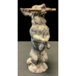 An early 20th century cast lead model of a Terrier Dog, standing on its hind legs, holding a stick