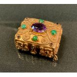 An amethyst and green stone and garnet cabochon mounted gold coloured metal pill box, wirework