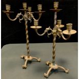 A pair of late 19th/early 20th century patinated bronze coloured metal adjustable tripod candelabra,
