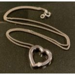 An 18ct white gold diamond heart pendant necklace, the open heart pendant set with a single round