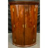 A George III mahogany bow front corner cabinet, moulded cornice, H-hinges, 115cm high, 76cm wide,